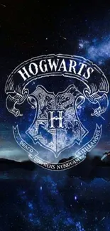 Hogwarts crest against a dark blue starry night sky wallpaper.