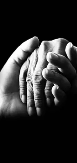 Black and white image of two hands holding together.