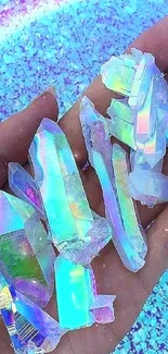 Holographic crystals resting on a hand over a vibrant blue background.