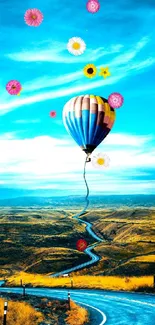 Hot air balloon over winding road, vibrant landscape.