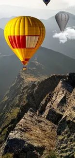 Vibrant hot air balloons over scenic mountain peaks wallpaper.