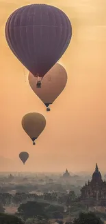 Hot air balloons soar above ancient temples at sunrise, casting a serene glow.