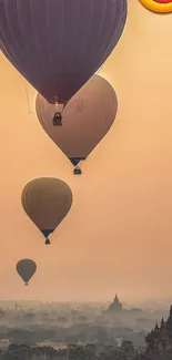 Hot air balloons rise over temples at sunrise.