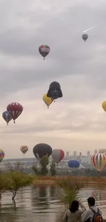 Colorful hot air balloons over city landscape.