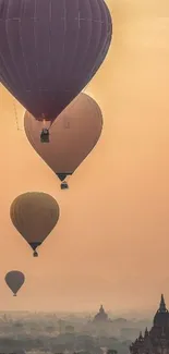 Hot air balloons rise over misty temples at sunrise in a scenic view.