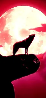 Wolf silhouette on a cliff under a vibrant red full moon.