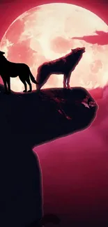 Silhouette wolves howling under a red moon on mobile wallpaper.