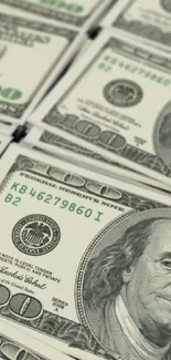 Wallpaper of hundred dollar bills stacked neatly.