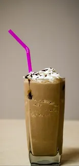Iced coffee with a pink straw in a glass.