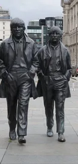 Four statues of an iconic band in an urban setting.