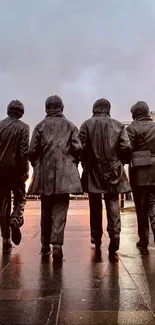 Four iconic statues walking in an urban city setting at dusk with reflections on wet pavement.