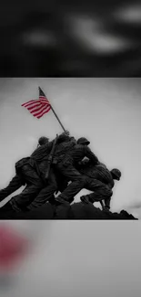 Iwo Jima flag-raising sculpture in grayscale with vivid flag.