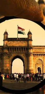 Gateway of India through a lens with a flag in the golden hour.