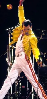 Performer in yellow jacket on stage in dynamic pose during a live concert.