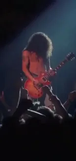 Guitarist performing live on stage with a vibrant concert crowd.