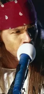 Rock musician with bandana singing on stage passionately.