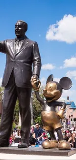 Statue holding hands with cartoon character outdoors.