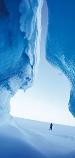 Person exploring a blue ice cave with surreal landscapes.