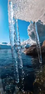 Icy landscape with clear water and sunlit icicles reflecting blue sky.