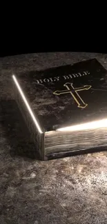 Illuminated Bible on stone surface with glowing cross.
