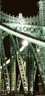 Illuminated bridge at night with lights reflecting on water.