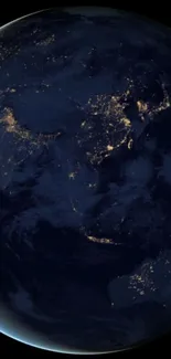 Earth from space at night with glowing city lights and dark blue oceans.