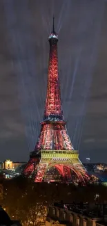 Eiffel Tower illuminated at night with vibrant red lighting and cityscape background.