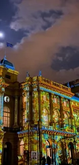 Illuminated historic building with vibrant urban art at night.