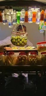 Street vendor stall illuminated with colorful drinks.