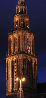 Illuminated historic tower against a deep blue night sky.