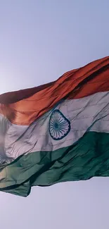 Indian flag waving in sunlight against a clear sky background.