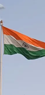 Vibrant Indian flag waving against a clear blue sky.