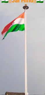 Indian flag flying high against clear blue sky.