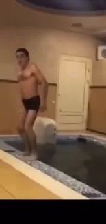 Person enjoying leisure time by a small indoor pool.