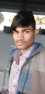 Industrial setting with young man taking a selfie in a warehouse.