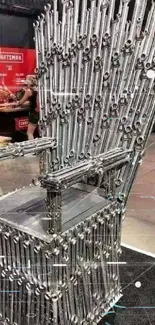 Innovative throne crafted from wrenches displayed at a design exhibit.