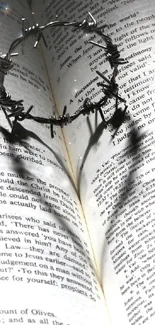Heart shadow on open book, symbolizing love and faith in grayscale.