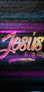 Colorful graffiti 'Jesus is my King' text on black brick background.