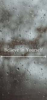 Raindrops on glass with 'Believe in Yourself' text.