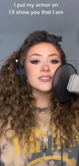 Woman recording music with microphone in a studio.