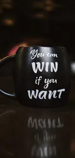 Black mug with motivational quote on dark background.