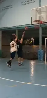 Two players in an intense basketball game on a blue indoor court.