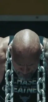 Man lifting chains during a workout session, sweating and focused.