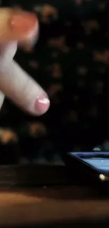 Closeup of fingers interacting with a smartphone screen on a dark background.