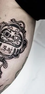 Intricate arm tattoo featuring bold lines and cultural symbolism.