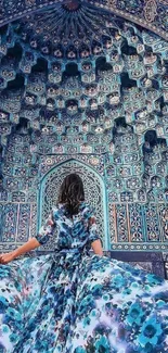 Woman in floral dress under intricate blue mosaic architecture.