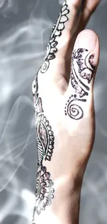 Close-up of a hand with intricate henna and soft smoky background.