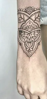 Intricate mandala tattoo design on arm with geometric patterns.