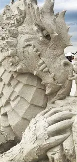 Intricate sand dragon sculpture with detailed textures at a beach.