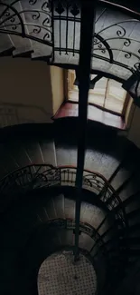 Intricate spiral staircase with vintage iron railing and dark aesthetic.